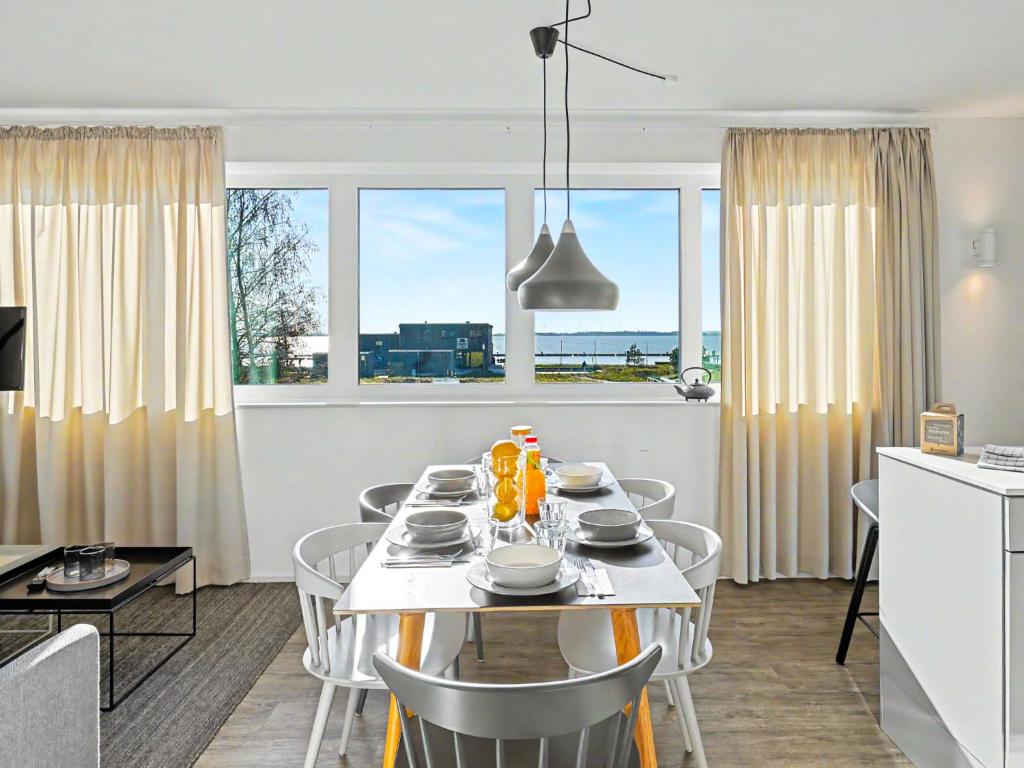 a dining room and kitchen with a table and chairs at Apartment Seeflair by Interhome in Lembruch
