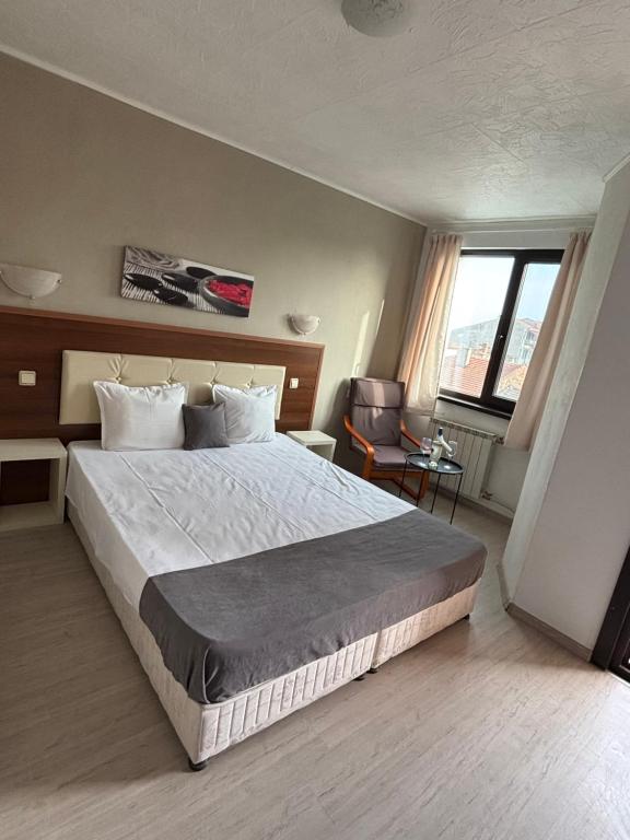 a bedroom with a large bed and a large window at Private Rooms Trakiets in Pomorie