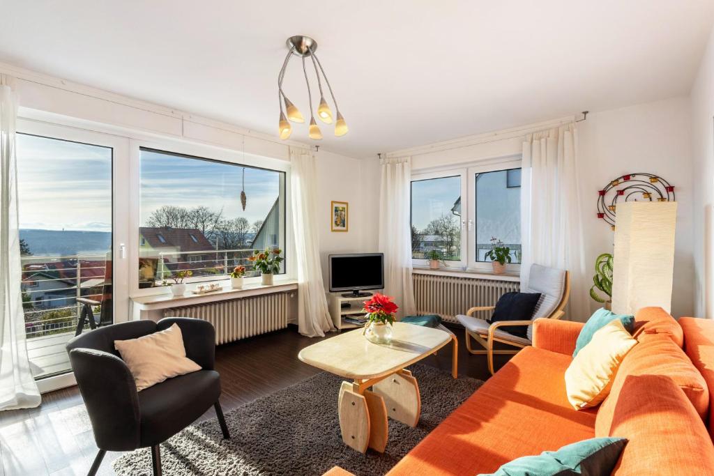 a living room with a couch and chairs and windows at Ferienwohnung In den Haargärten in Möhnesee