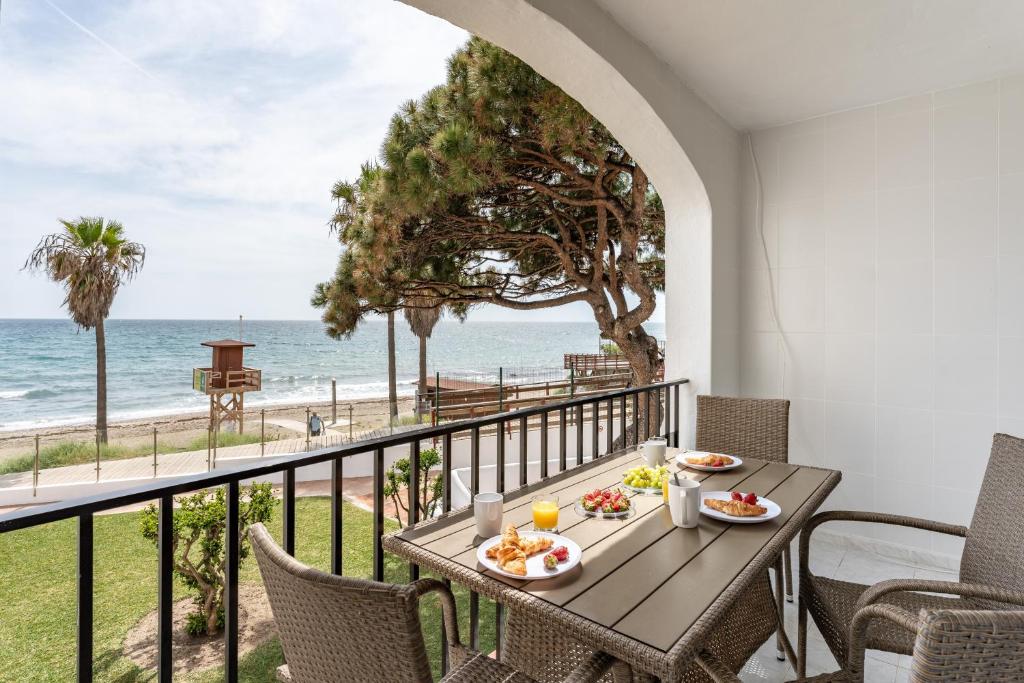 a table with food and a view of the ocean at Sea Front Beach House Micaela I in Marbella