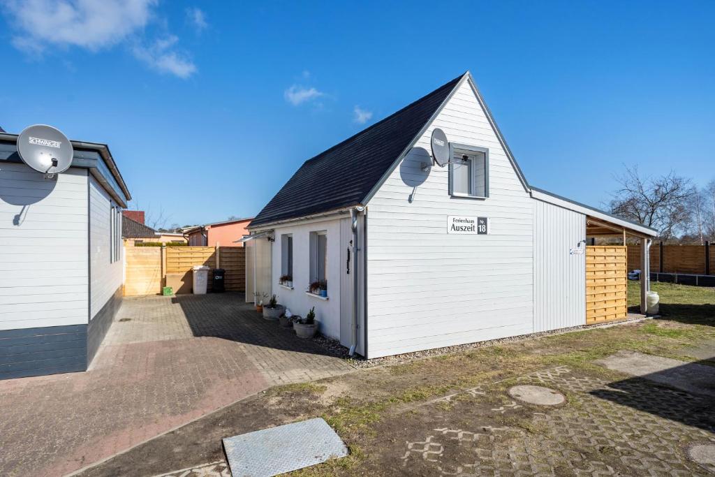 a white house with a roof and a garage at Auszeit Nr 18 in Zempin