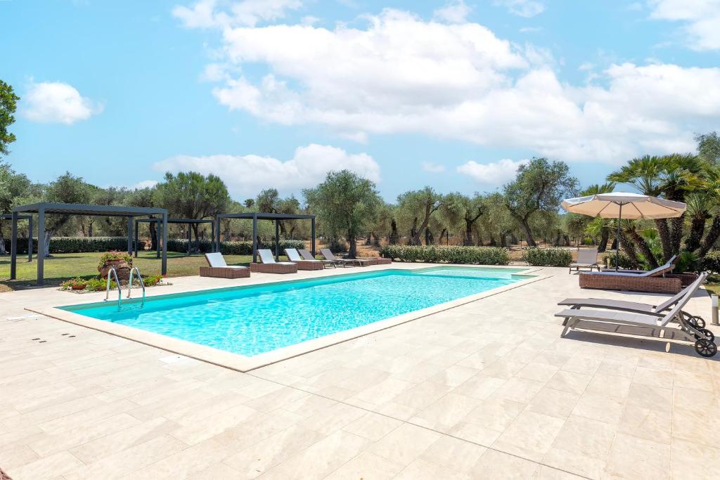 a swimming pool with chairs and an umbrella at Dimora Sella Rooms in Alghero