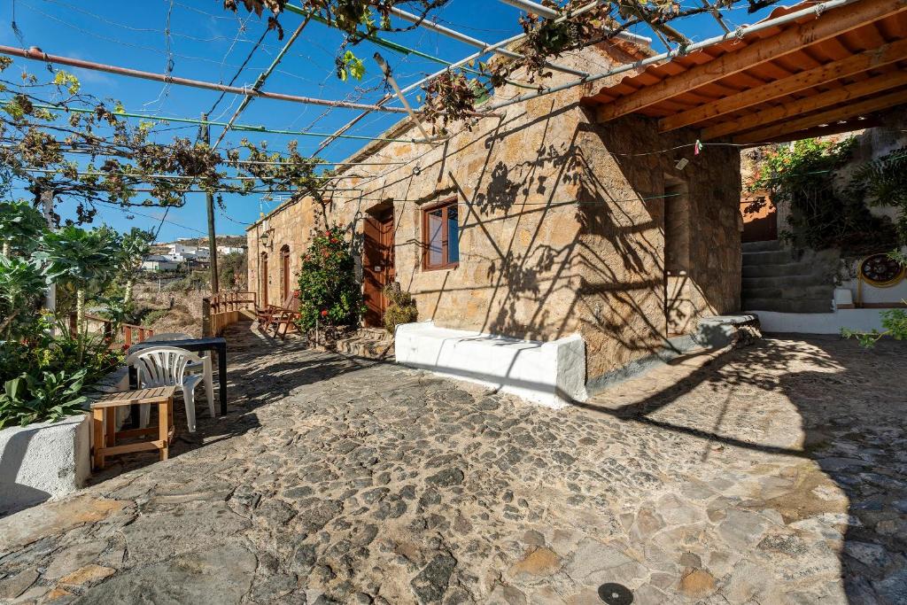 a house with a stone walkway next to a building at Eco Holidays House Races in Fasnia