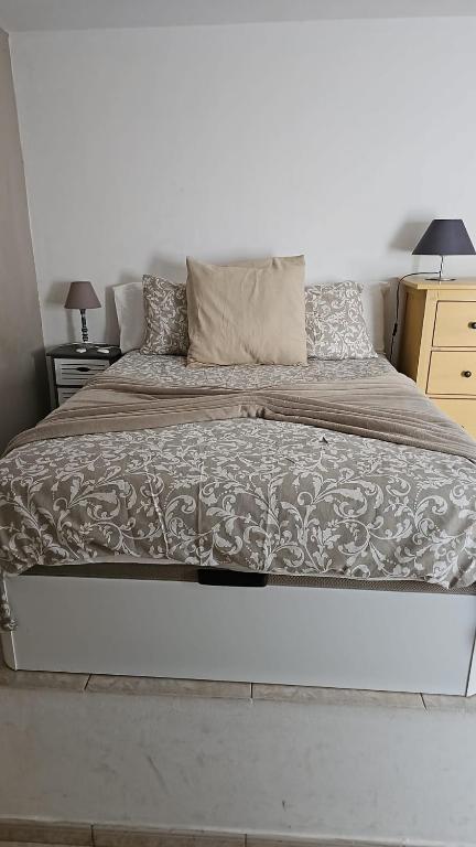a large bed in a bedroom with two lamps at Sweetcasitaarinagaplaya in Arinaga