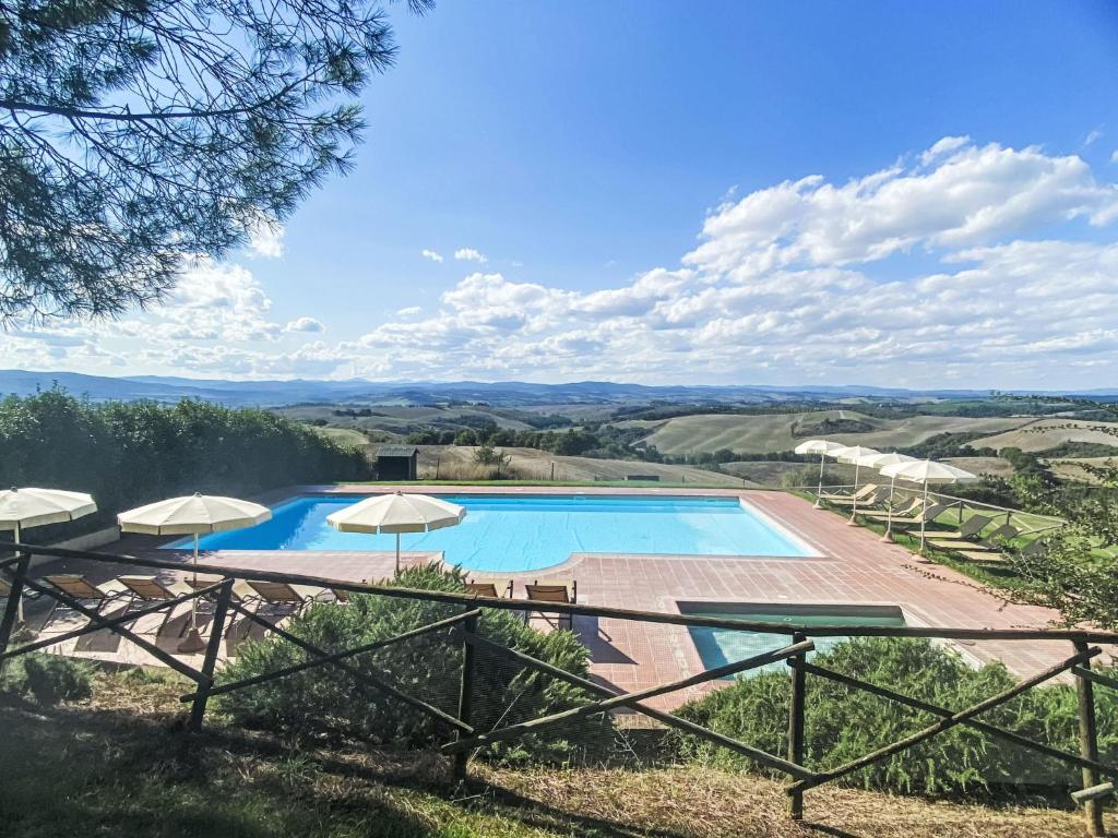 a view of a pool with umbrellas at Apartment Asciano by Interhome in Vergelle