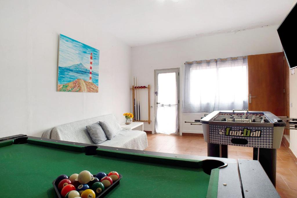 a living room with a pool table and a couch at El Faro Sardina in Sardina
