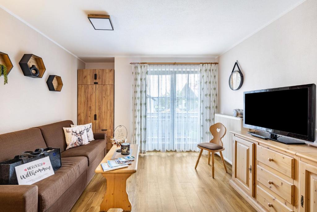 a living room with a couch and a flat screen tv at Fewo Brünnstein - Nr 27 Pool, Sauna in Oberaudorf
