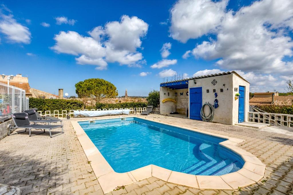 a swimming pool in a yard with a house at Charmante location vacances in Montagnac