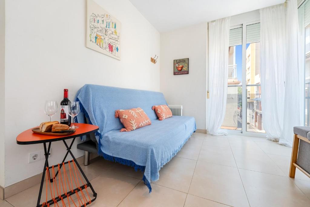 a living room with a blue couch and a table at Apartamento Sf1 in L'Ametlla de Mar