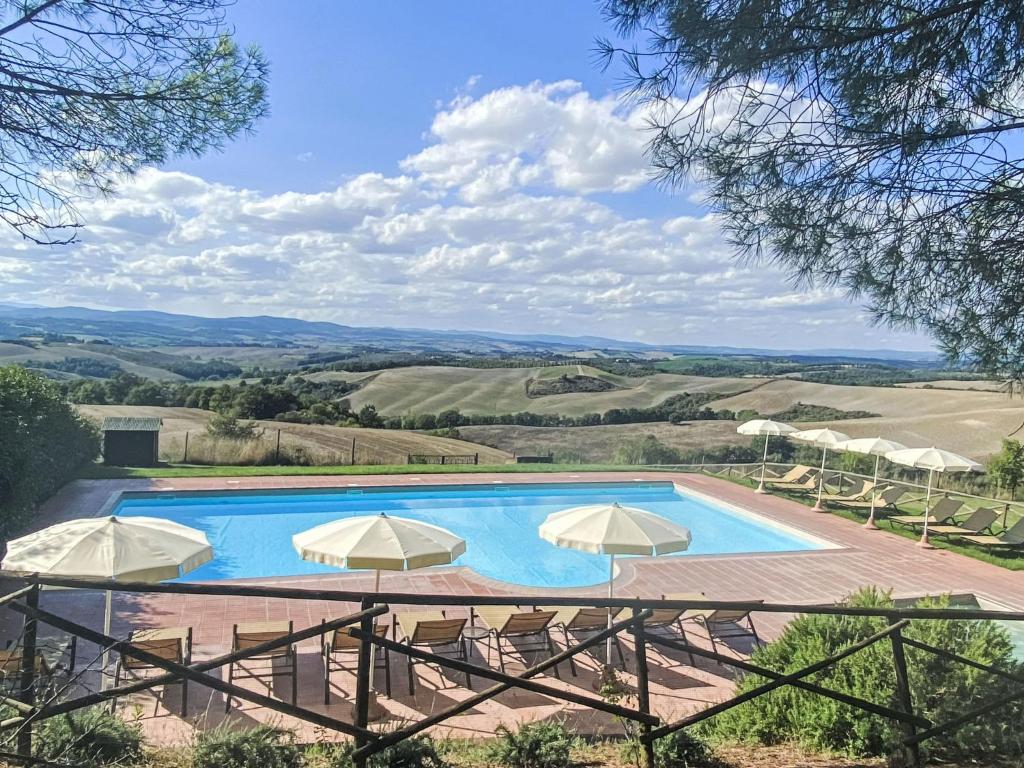 a pool with umbrellas and a view of the rolling hills at Apartment Monteroni by Interhome in Vergelle