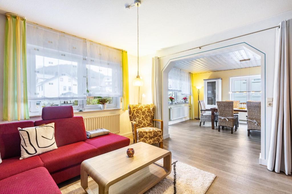 a living room with a red couch and a table at Ferienwohnung Brune in Schmallenberg