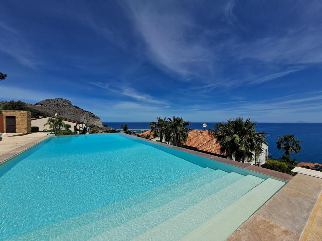 a large swimming pool with a view of the ocean at Magarà Apartment by Casa in mente in Cefalù