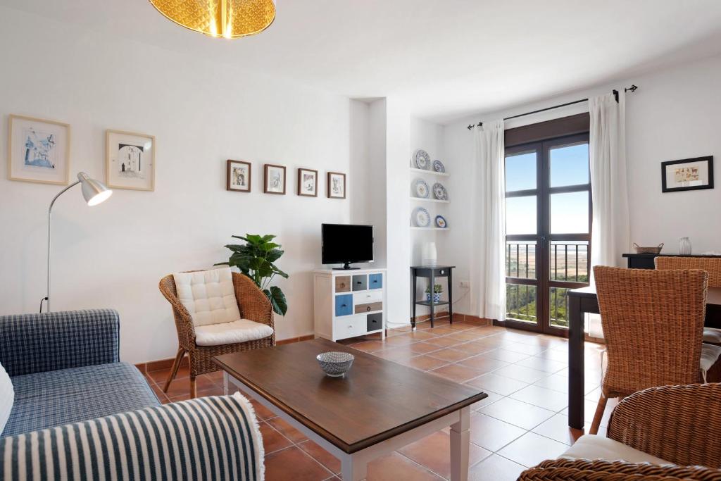 a living room with a table and chairs and a tv at Cobijadas75 Janda in Vejer de la Frontera