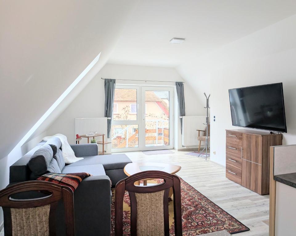 a living room with a couch and a tv at Ferienwohnung Waldblick in Fuhlendorf