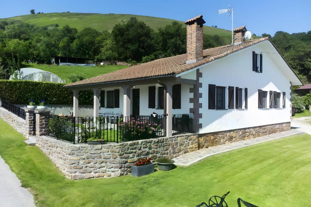 a white house with a stone wall at Oiaraberri in Errazu