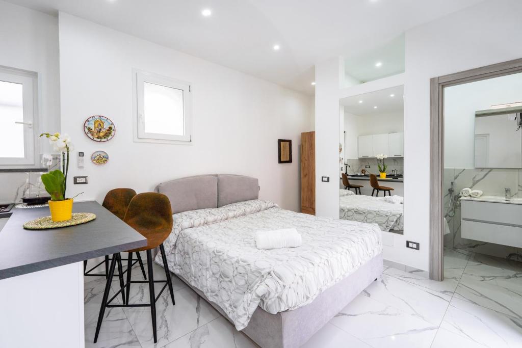 a bedroom with a bed and a table and a bathroom at P&P Apartment in Forio d'Ischia