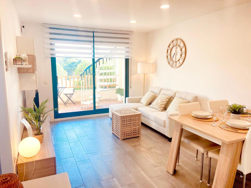 a living room with a white couch and a table at Atico Solarium La Cala in Miami Platja
