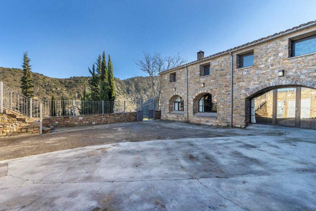 an empty parking lot in front of a brick building at Rectoria de Claverol in Claverol