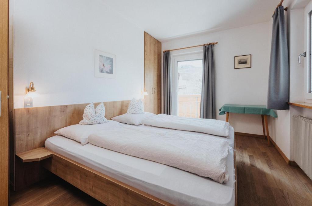 a large bed in a room with a window at Unterhauserhof App A in Valdaora