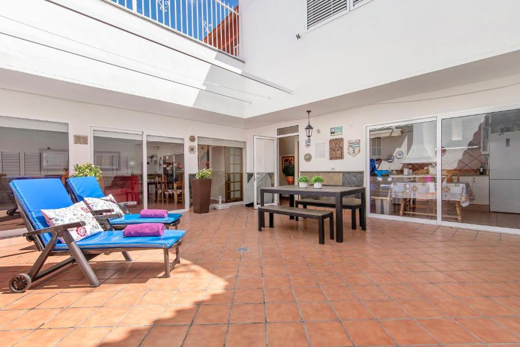 a living room with blue chairs and a table at Casa Paca in Maspalomas