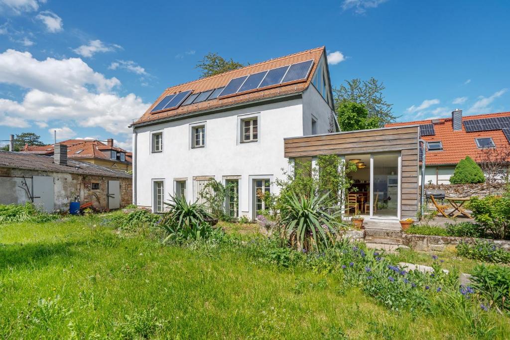a white house with solar panels on its roof at Ferienhaus im Vorwerk Nickern in Dresden