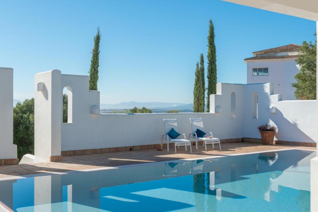 a villa with a swimming pool and white walls at Villa Muscari in Benalup Casas Viejas