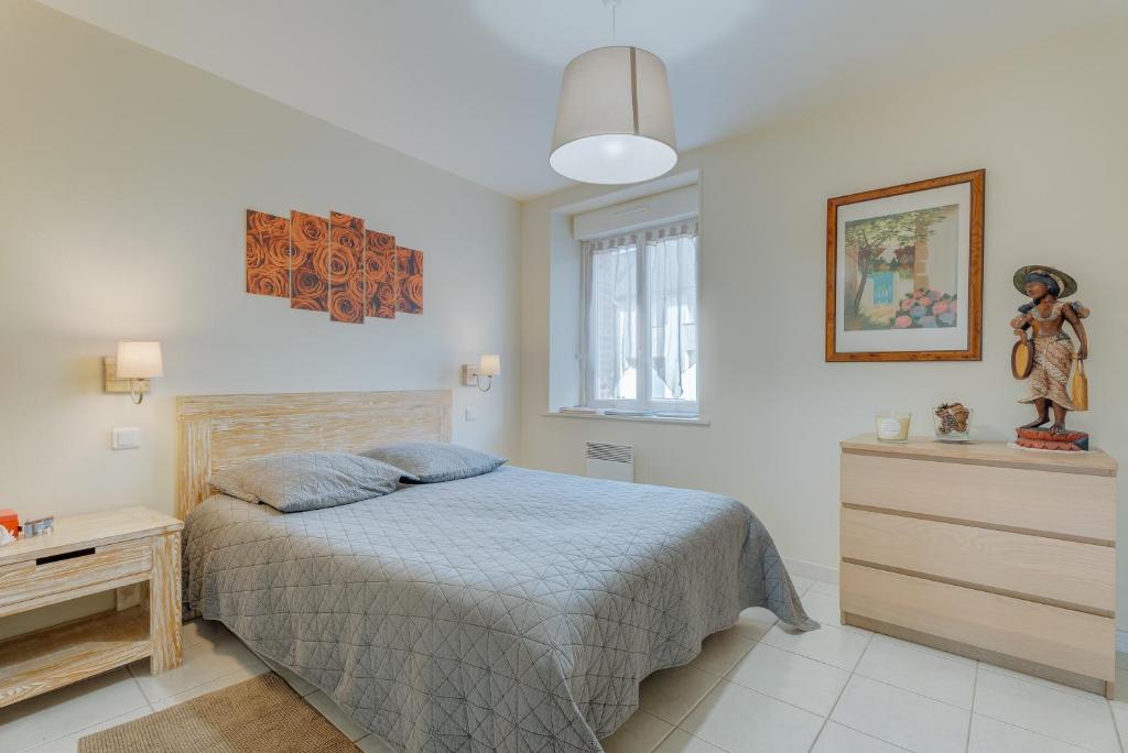 a bedroom with a bed and a dresser at Grain de vanille in Saint-Benoît-des-Ondes