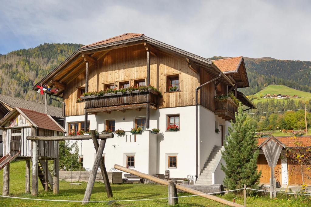 a large wooden house with a balcony on top at Inneroswalderhof in Anterselva di sotto