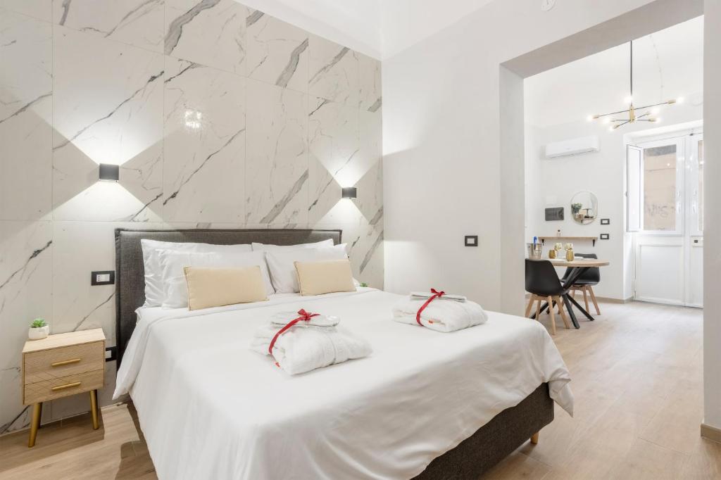 a bedroom with a large white bed with two pillows at Piccolo Incanto Spa Palermo in Palermo