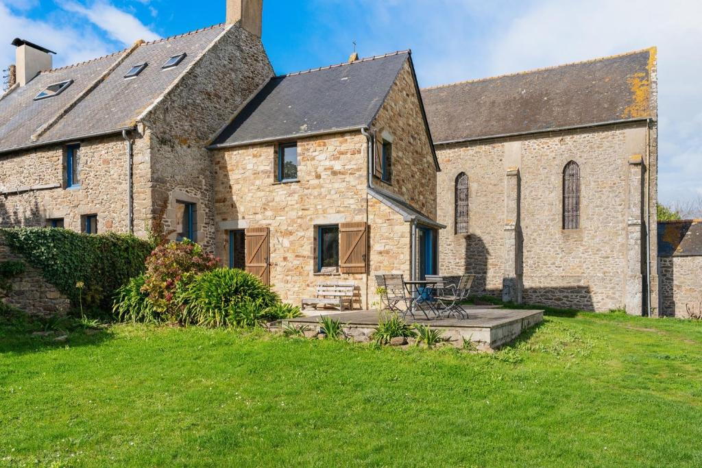 a large brick building with a grassy yard at Maison Plage Verger Cancale in Cancale