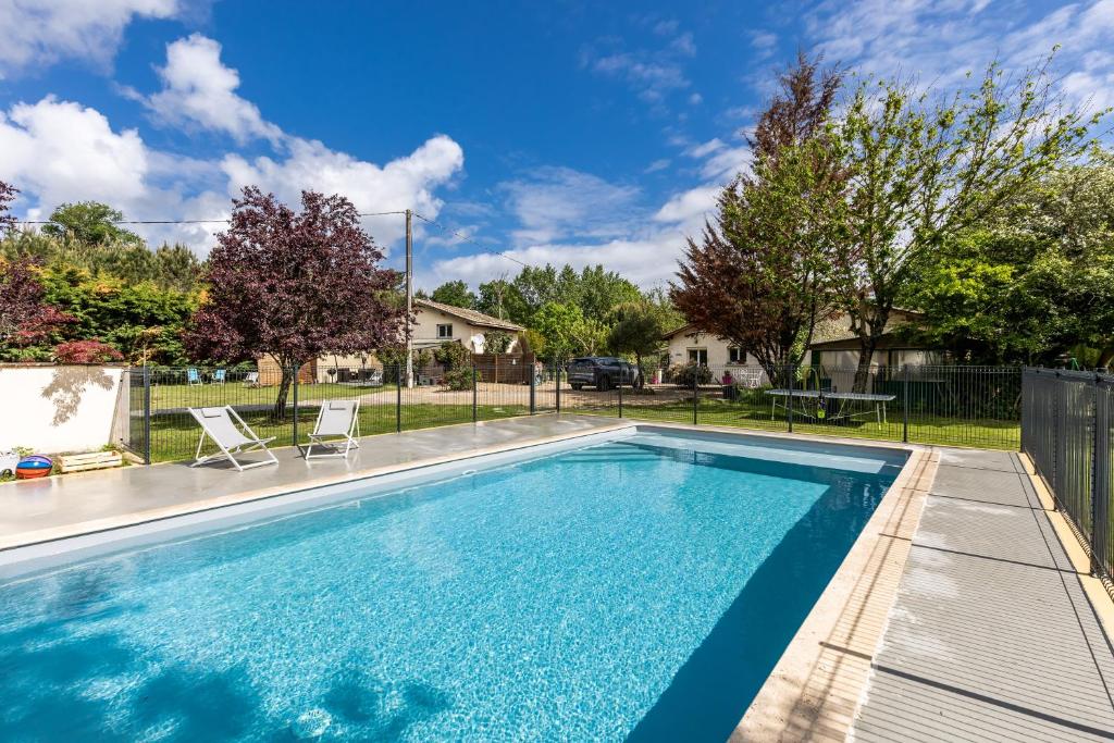 a swimming pool in a yard with a fence at Gite Senguinous 1 in Lesparre-Médoc