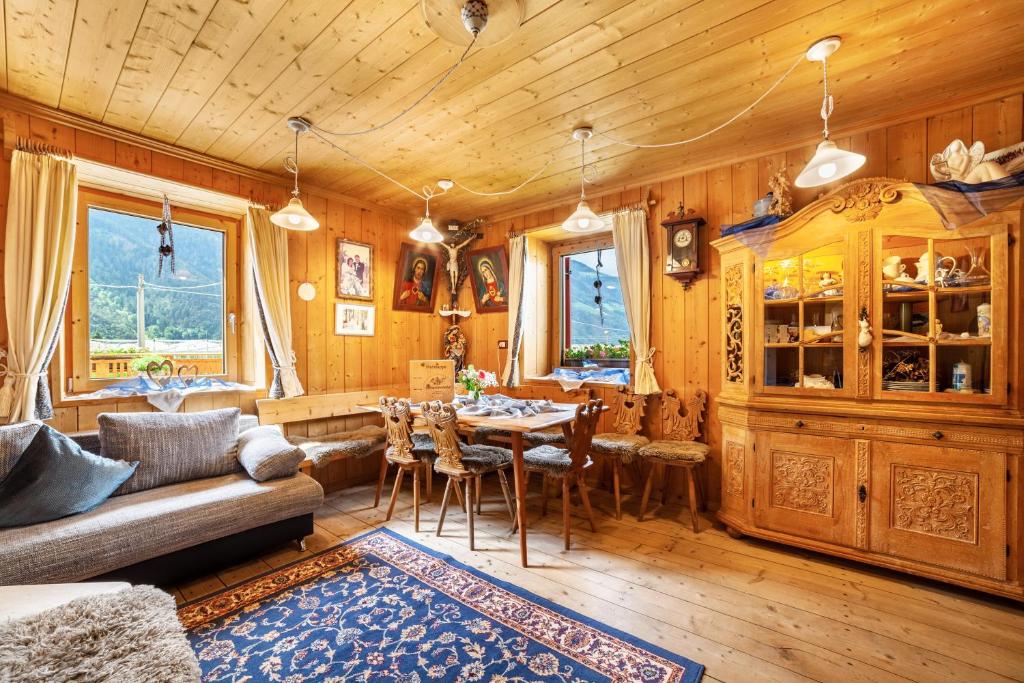 a living room with a table and a wooden ceiling at Sagschneiderhof Golden Delicious in Plaus