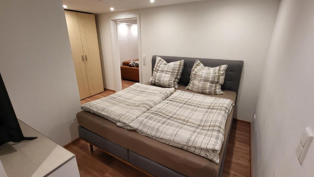 a small bedroom with a bed with pillows on it at Ferienwohnung Burgstraße in Fuldatal