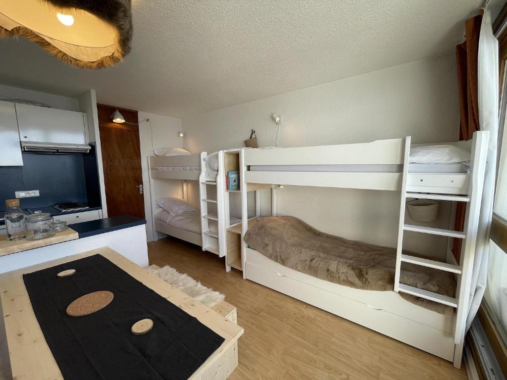 a room with two bunk beds and a kitchen at Brelin - Combes in Les Menuires