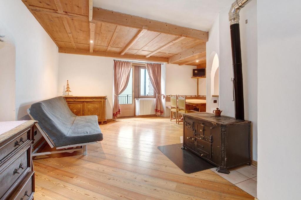 a living room with a wooden floor and an old stove at Premesan 5 in Bormio