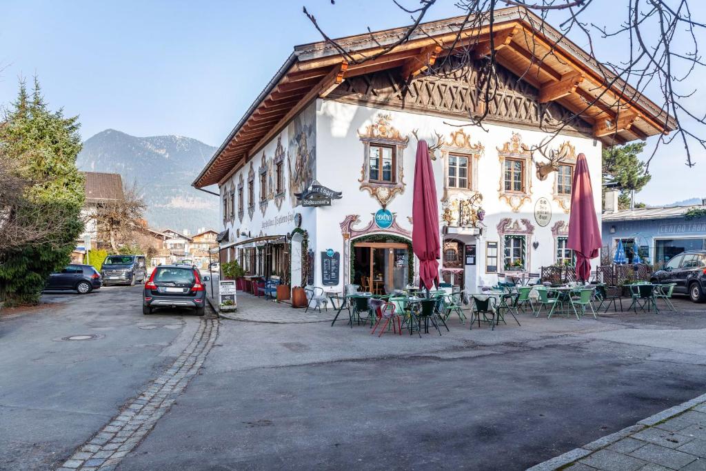 a building with tables and chairs in front of it at Ferienwohnung siebzehn35 in Garmisch-Partenkirchen