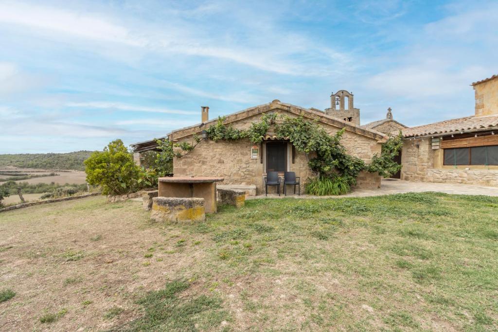 a stone house with a table in front of it at La Caseta De Sant Grau in Navés