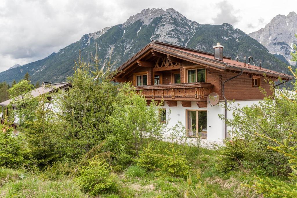 a house on a hill with mountains in the background at Mountainlodge in Leutasch