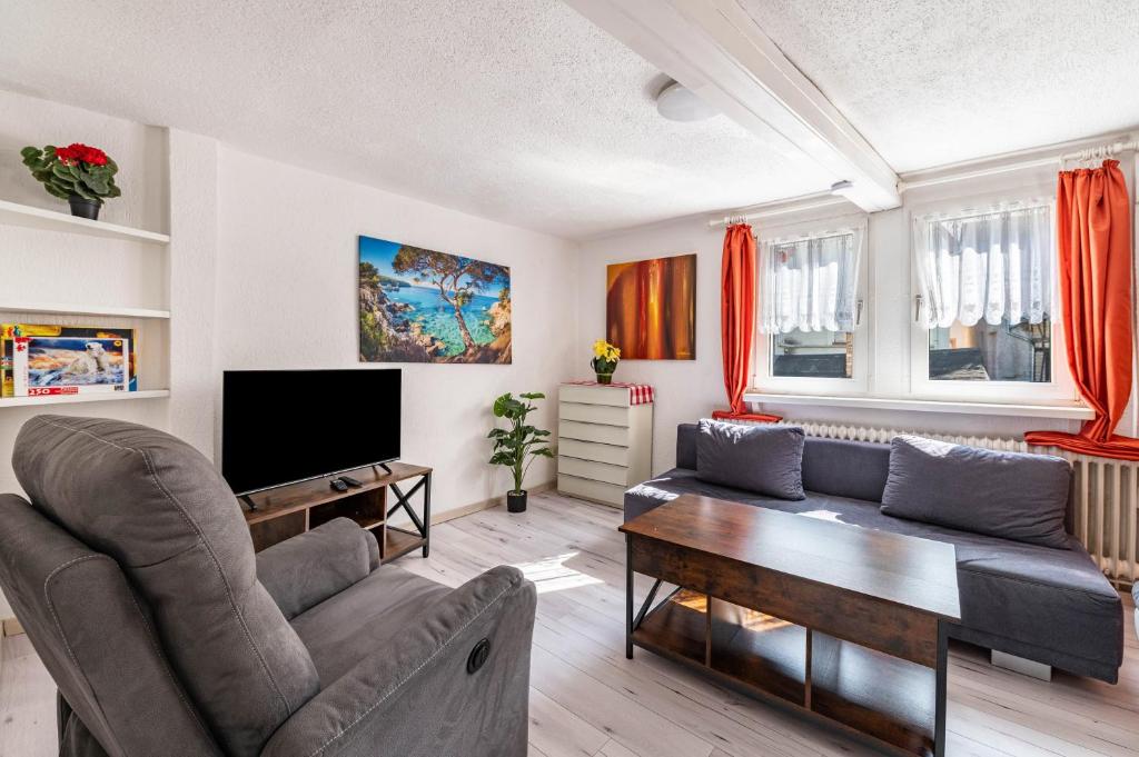 a living room with a couch and a tv at Ferienhaus bei Reichsburg Cochem in Cochem