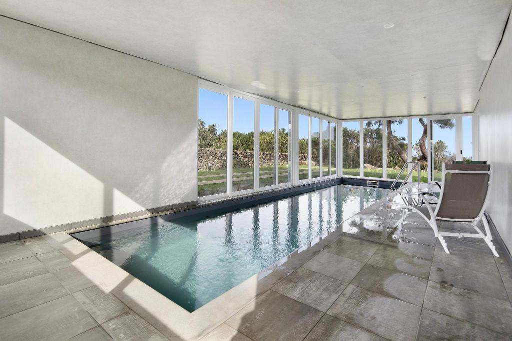 ein Swimmingpool in einem Haus mit einem großen Fenster in der Unterkunft Rocha do Mar 1 in Biscoitos