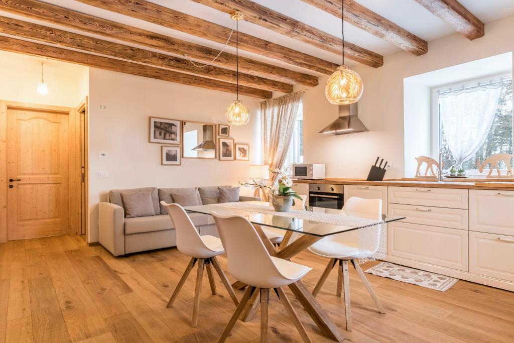 a kitchen and living room with a table and chairs at Wellness Lodge Edoardo in Santa Giuliana