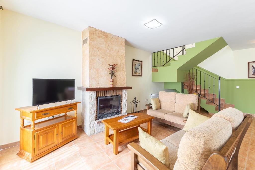 a living room with a tv and a fireplace at La Casa de Dafne Almendro in Santo Tomé del Puerto