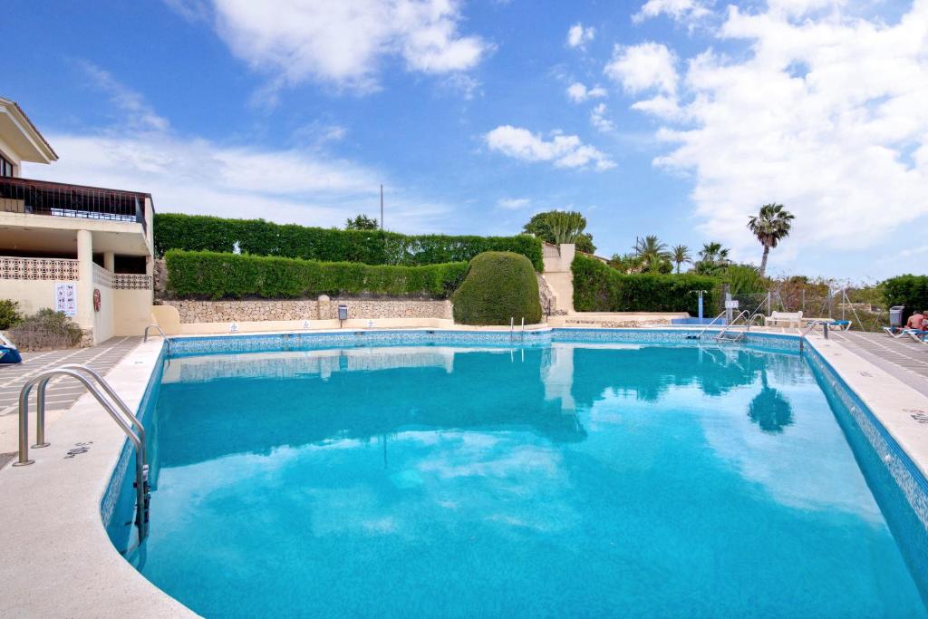 a large swimming pool with blue water at Dulce Amor in Casas Abiar