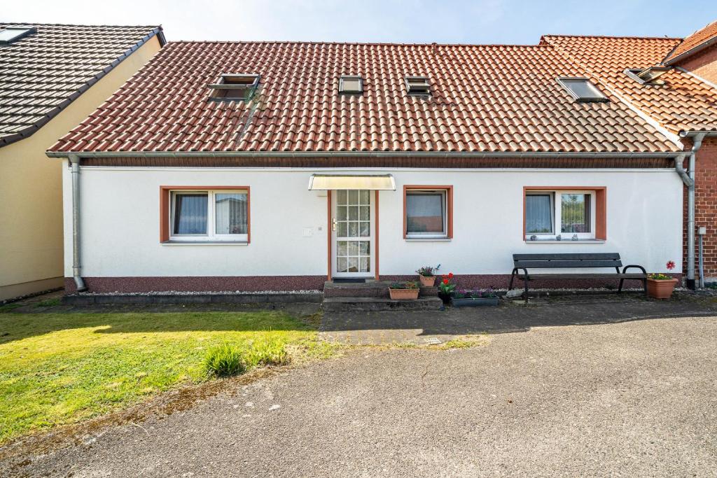 a white house with a bench in front of it at Ferienwohnungen in Starsow in Mirow