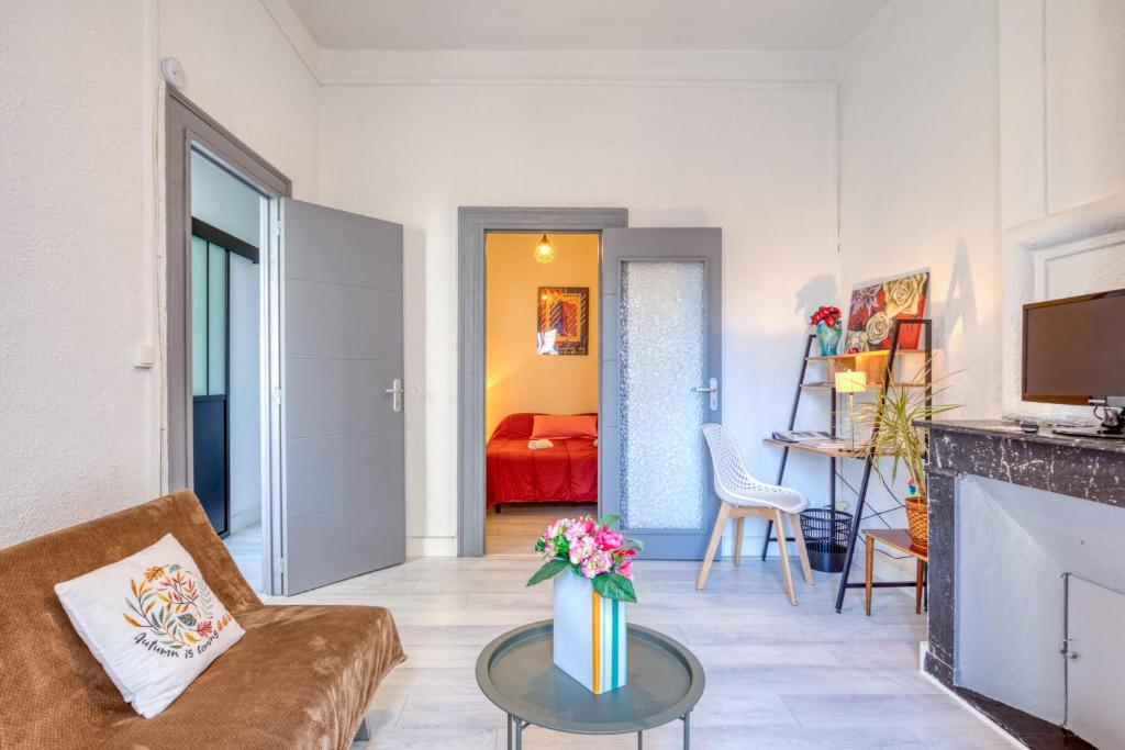 a living room with a couch and a table at Appart - Sète quartier des Artistes in Sète