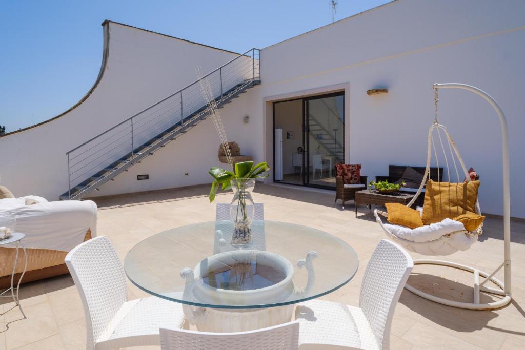 a living room with a glass table and chairs at Villa Scoglio in Melendugno