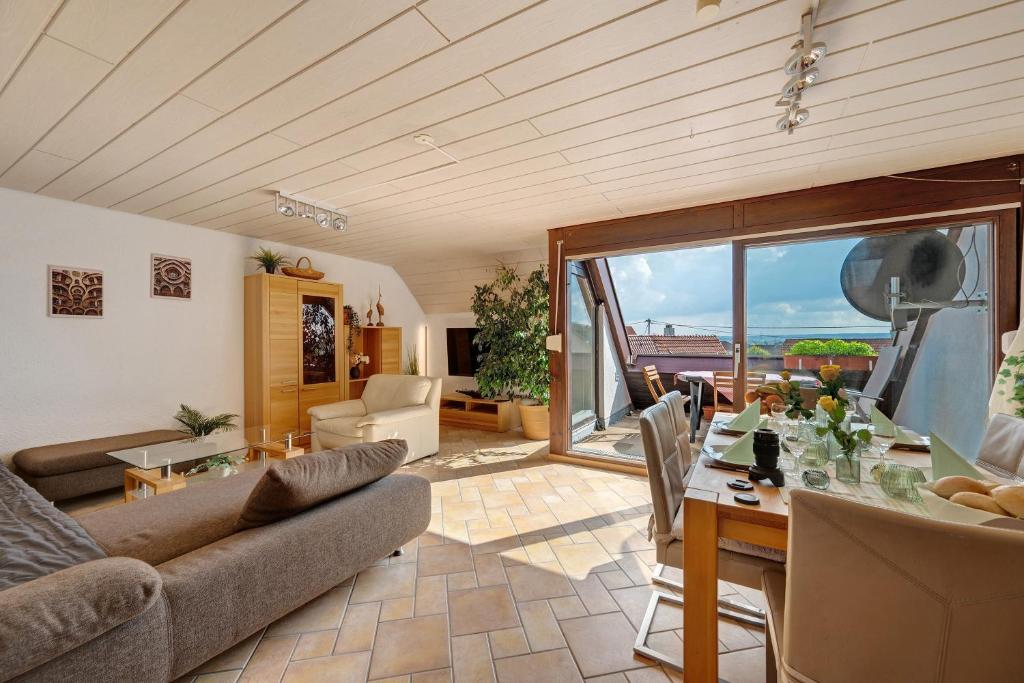 a living room with a table and a dining room at Großzügige Maisonettewohnung in Sindelfingen