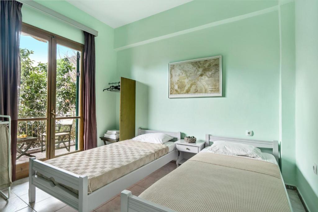 a bedroom with two beds and a balcony at Old Boat double studio 6 in Nikiana