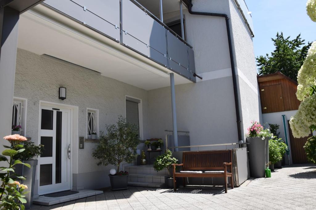 a house with a bench on the side of it at Bodensee Apartment Gresser in Meckenbeuren