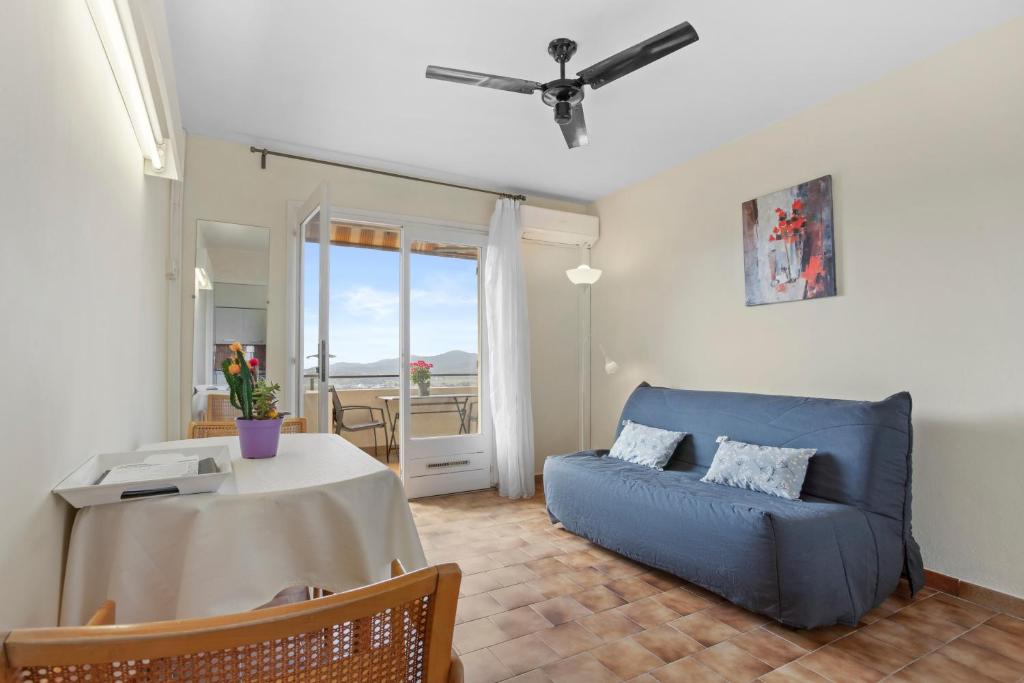 a living room with a blue couch and a table at Le Mas Berliat N°9 in Bormes-les-Mimosas
